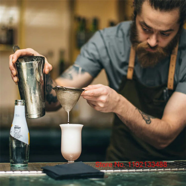 Serveur qui fait un cocktail dans le verre tulipe