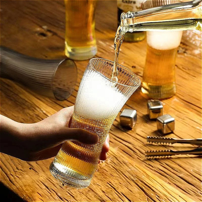 Un verre à bière devant une tireuse à bière