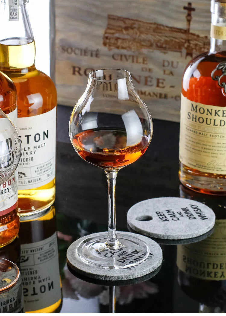Un verre tulipe avec des bouteilles de whisky