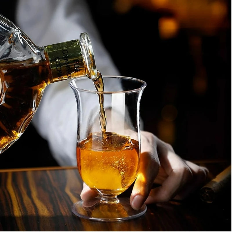 Serveur qui verse du whisky dans le verre tulipe