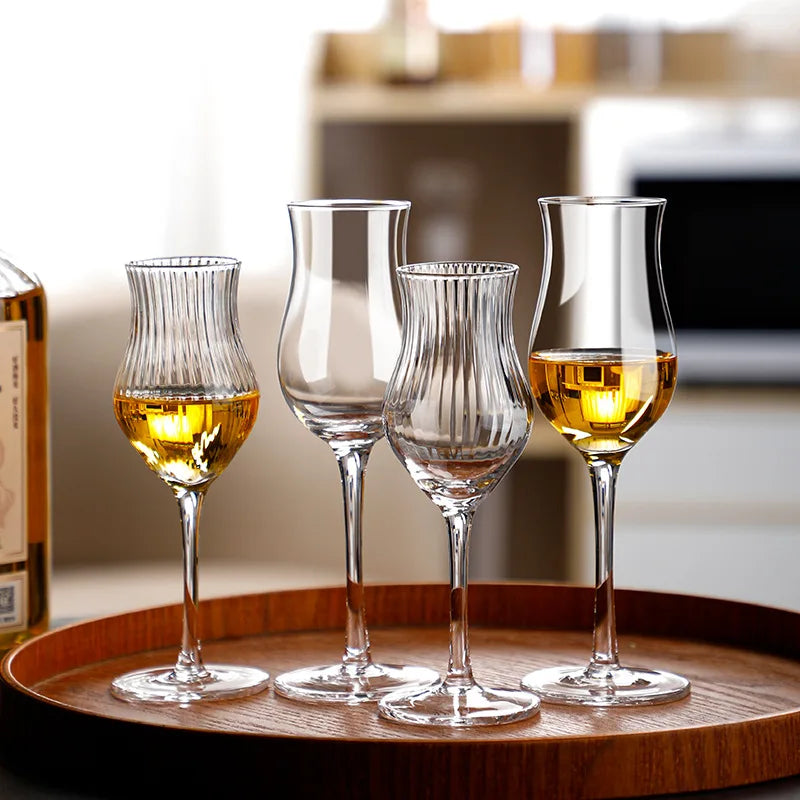 Quatre verres tulipe dans un plateau avec une bouteille de whisky japonais