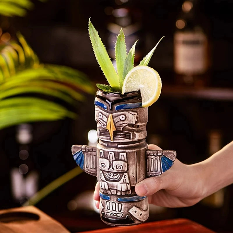 Un verre tiki dans une main d'homme sur un bar